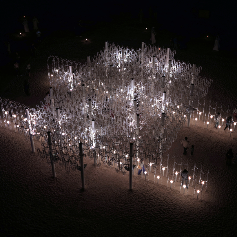 cloud-like white canopy of hanging vines emerges from abu dhabi’s arid landscape