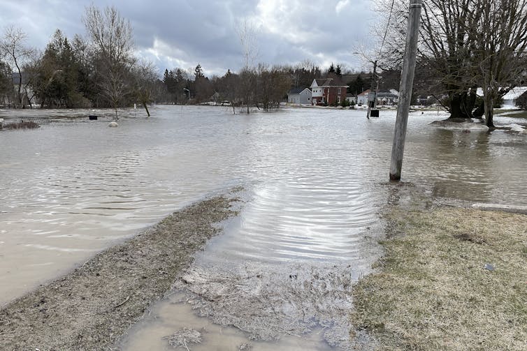 A town street underwater from a river that overflowed its banks.