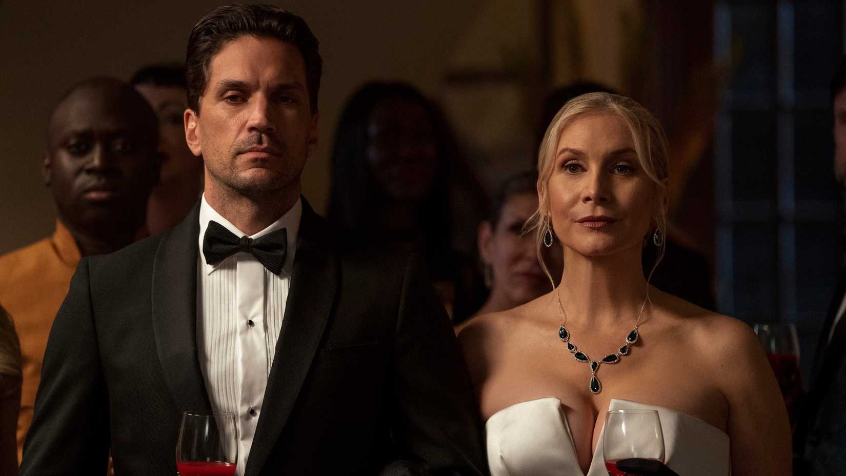 Margot (Elizabeth Mitchell) and Sebastian (Will Swenson) Fairmont in formal wear, drinking blood out of wine glasses in First Kill.