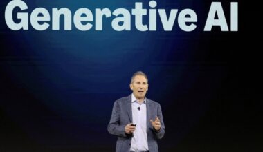 Andy Jassy speaks on stage in front of a large screen displaying the words “Generative AI.”