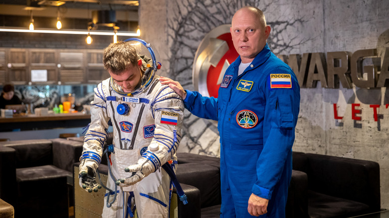 Cosmonaut Oleg Artemyev explaining suit details to the press.