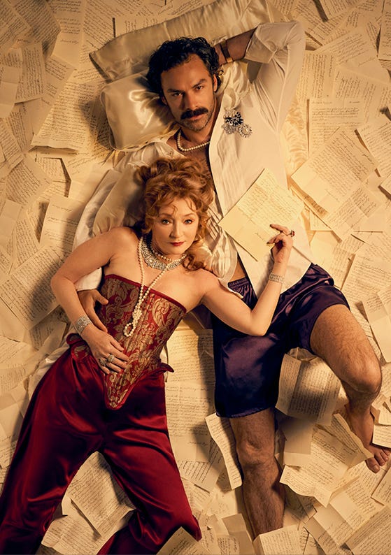 a couple lying on scattered handwritten sheets of paper dressed in elegant attire