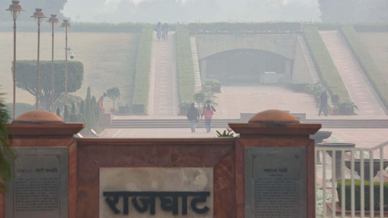 People visit the Rajghat as a layer of smog engulfs the city amid deteriorated air quality.