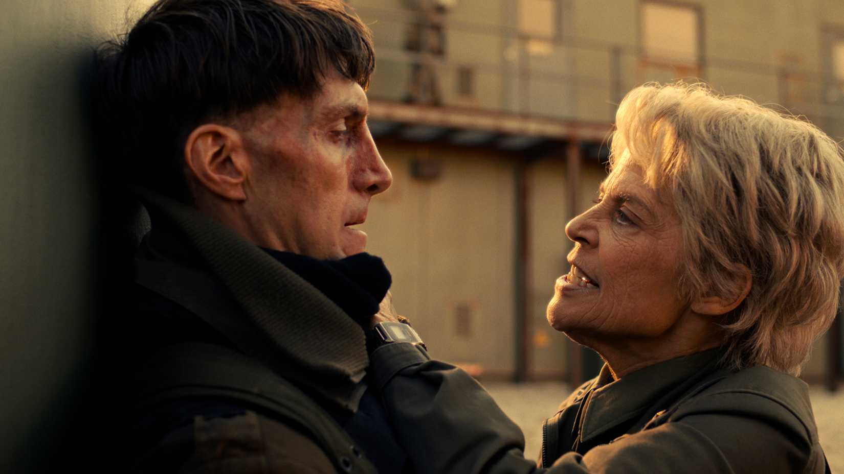 Dr. Kay holding a soldier's neck up against the wall looking angry in Stranger Things.