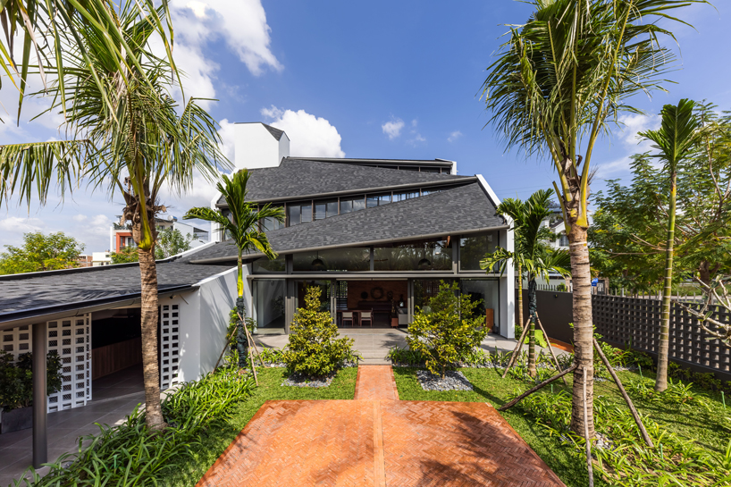 tent house expands under overlapping angular roof planes in vietnam