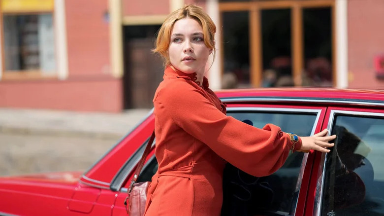Charlie Ross (Florence Pugh) looks back from a red car in The Little Drummer Girl