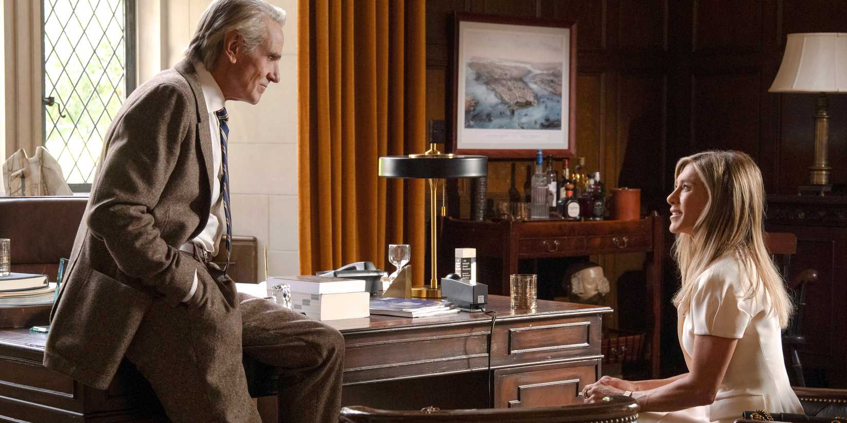 A man talking to Alex Levy (Jennifer Aniston) in an office in The Morning Show season 4