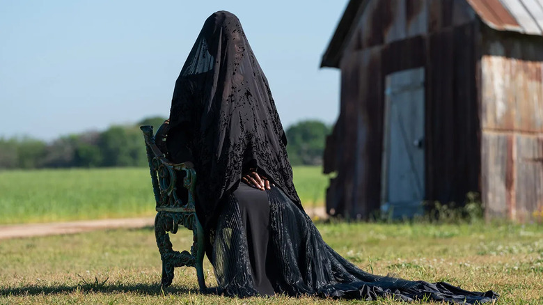 Okwui Okpokwasili as the Woman, sitting in the yard in The Woman in the Yard
