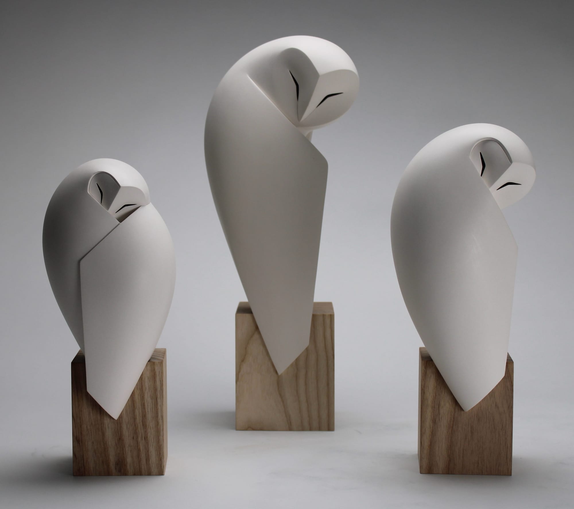 three stone owl sculptures by Anthony Theakston