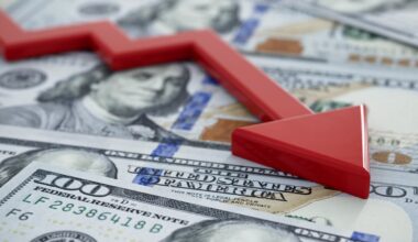 A downward-moving red arrow atop U.S. currency.