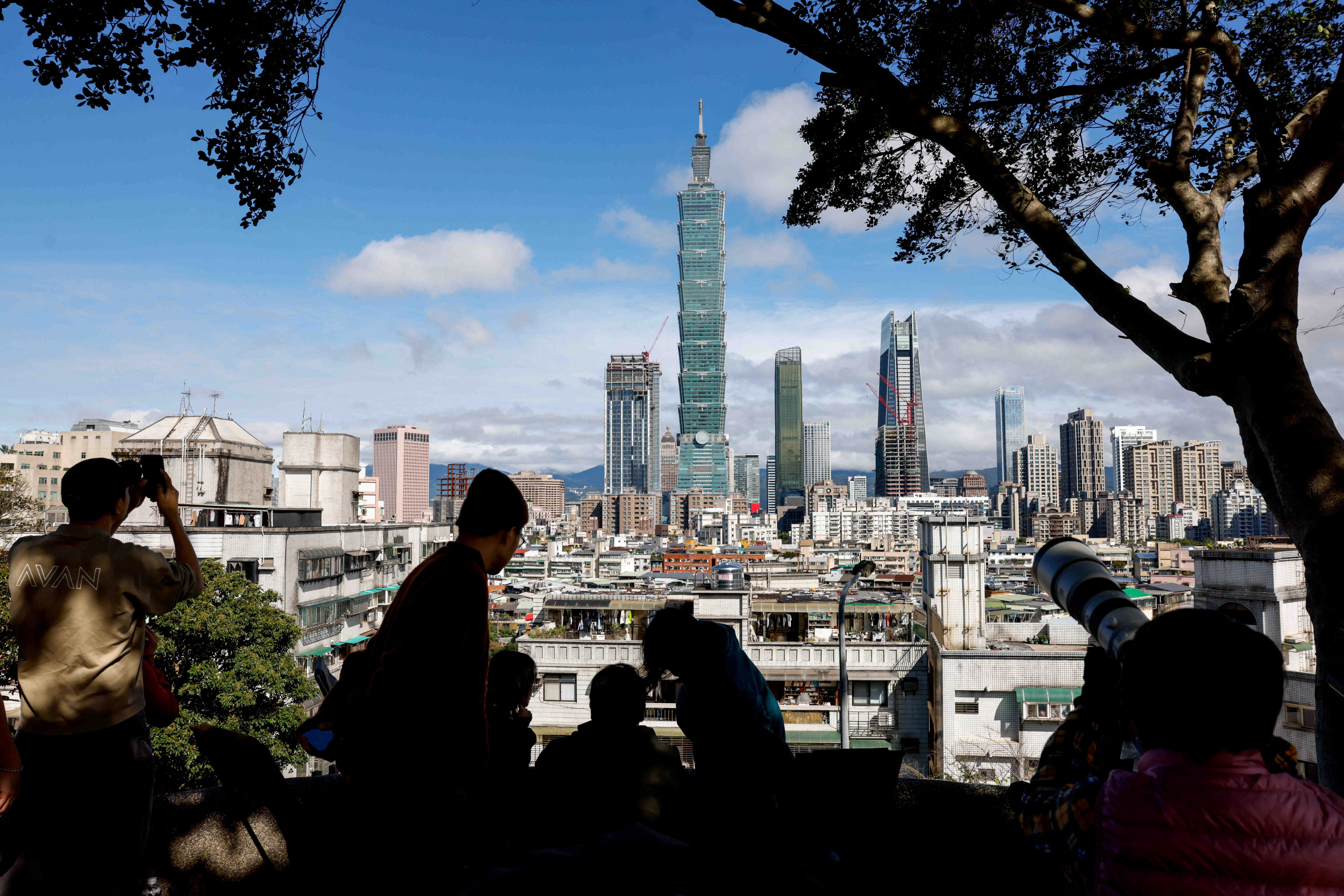 People gather to watch climber Alex Honnold free soloing Taipei 101 Skyscraper.