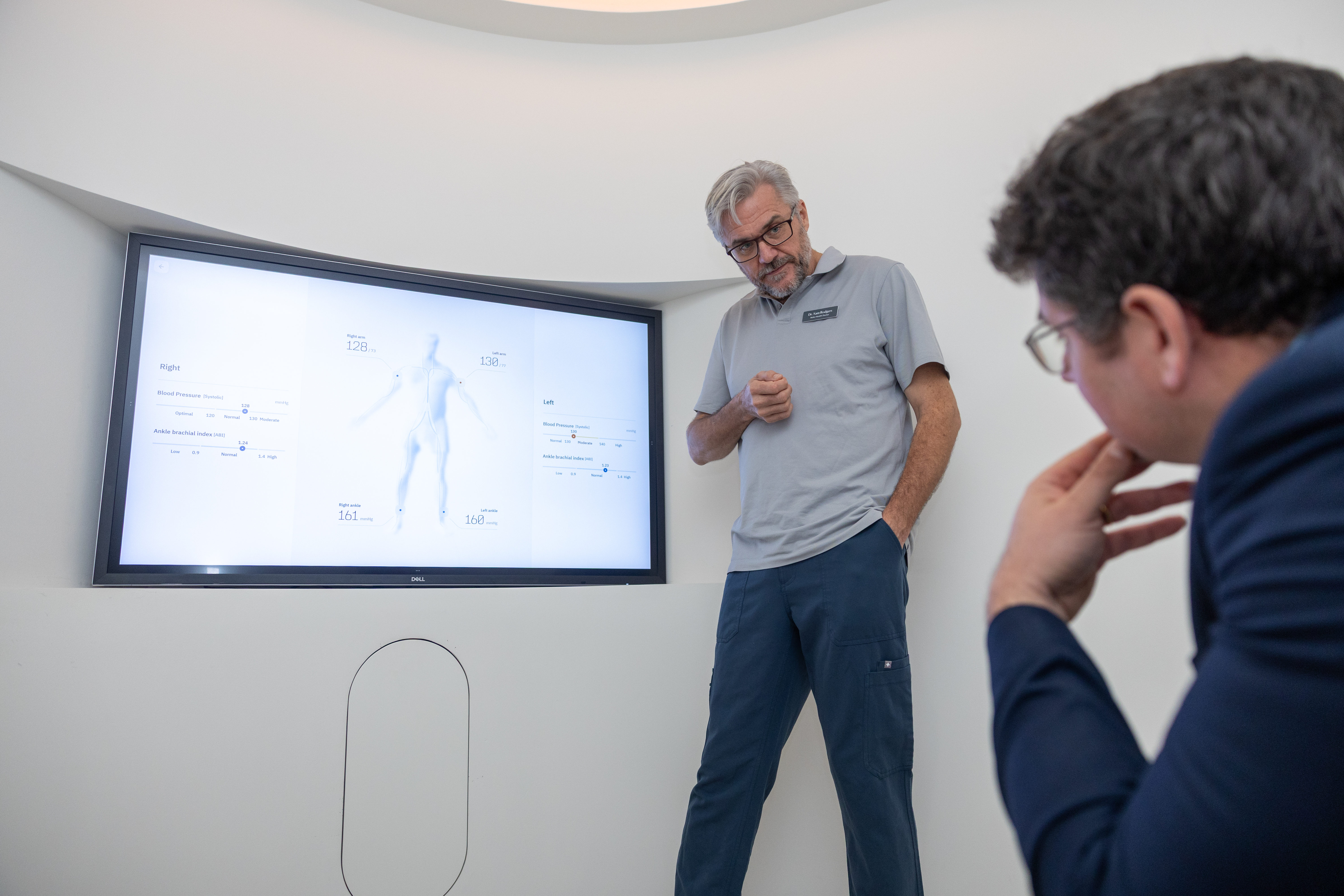 Sam Rodgers, Lead GP, showing Ben Spencer a medical presentation on a large screen at Neko Health.