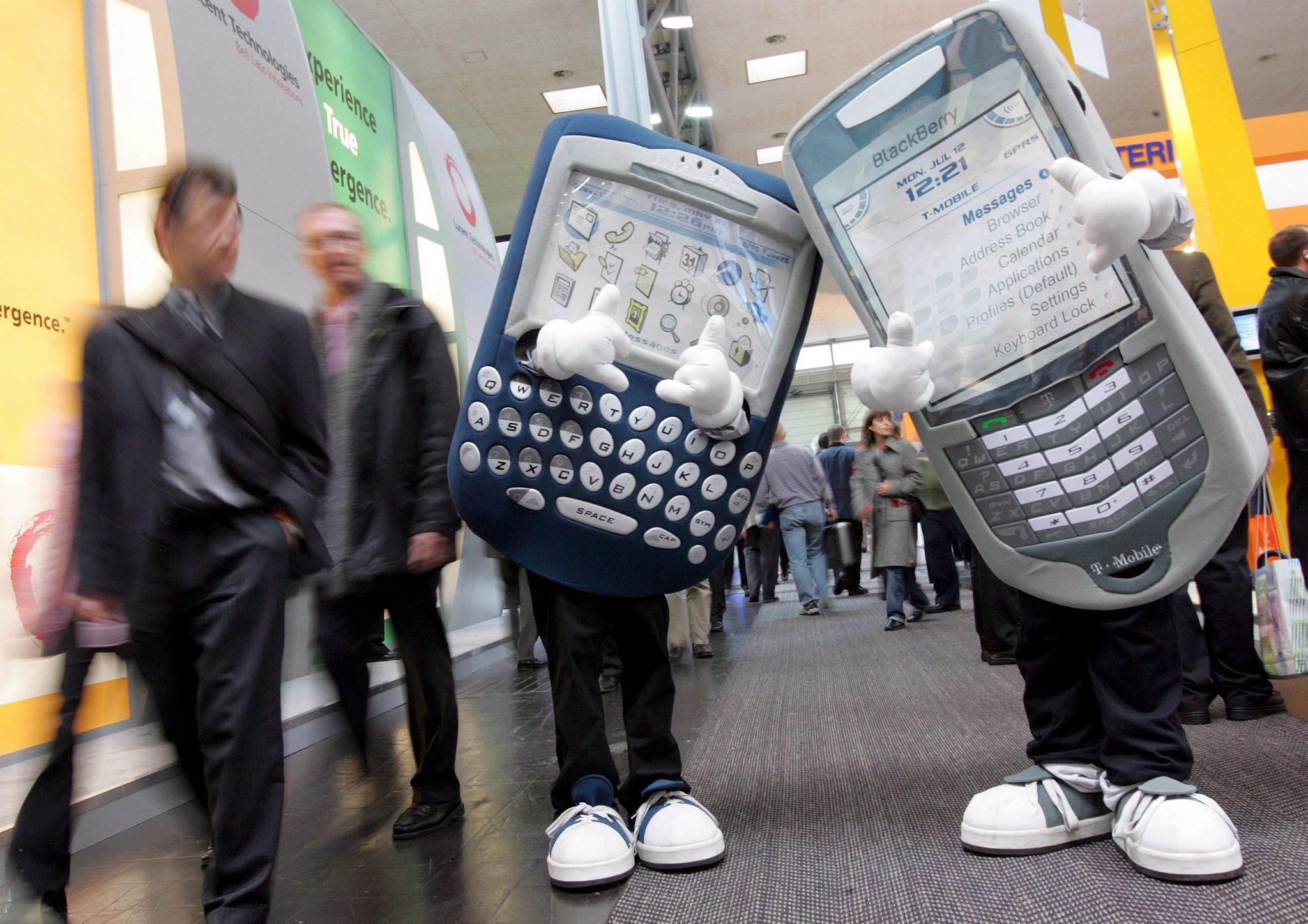 Two models dressed as oversized Blackberry telephones at a trade fair.