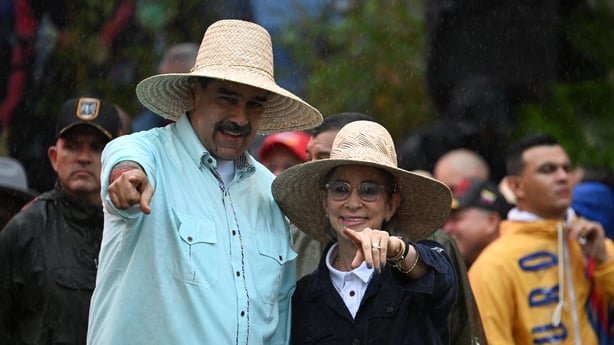 Venezuela's President Nicolas Maduro gestures next to his wife, First Lady Cilia Flores, during a rally to mark the anniversary of the Battle of Santa Ines, in Caracas on December 10, 2025.