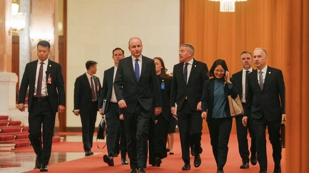 Ireland's Prime Minister Micheal Martin (C) walks with his delegations as they arrive at the Great Hall of the People to meet with China's President Xi Jinping in Beijing on January 5, 2026. (Photo by Andy Wong / POOL / AFP)