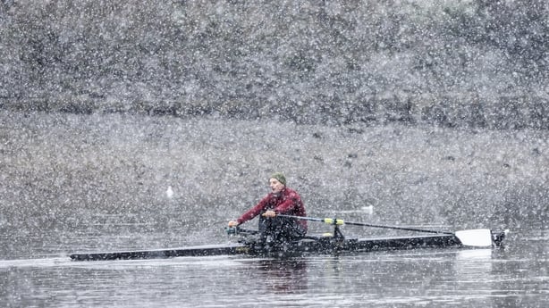A rower is caught in heavy snow in London, England