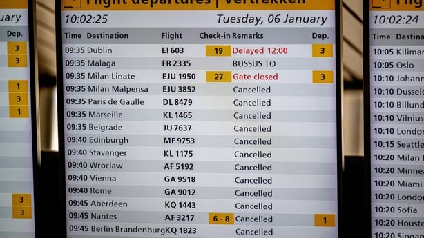 This photograph shows a flight departures information board displaying numerous cancellations at the Schiphol Airport