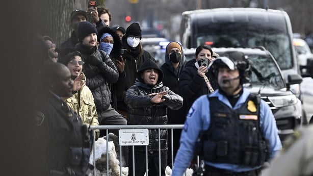 People gather near the scene of a suspected shooting by an ICE agent 