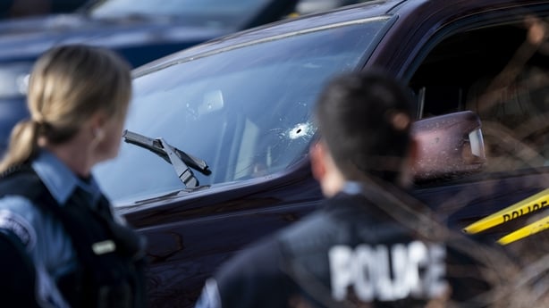A bullet hole is seen in the windshield of a vehicle involved in a shooting by an ICE agent