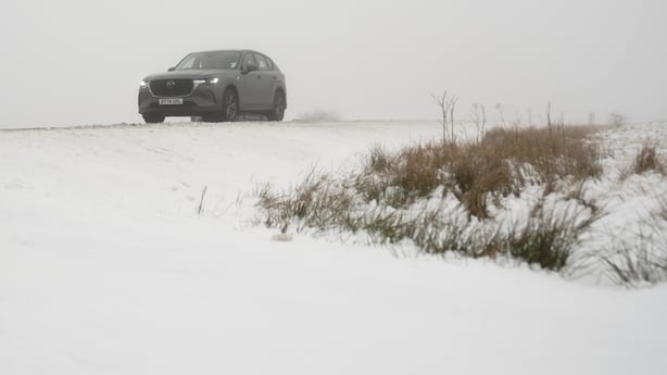 A car being driven through snow on a main road in the Peak District of England
