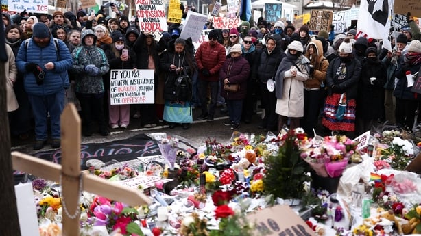 People gather at a makeshift memorial for 37-year-old Renee Nicole Good