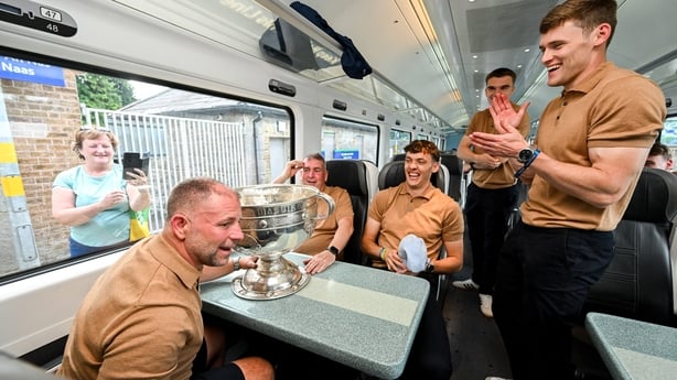 28 July 2025; Kerry players and backroom staff, from left, head of athletic development Jason McGahan, county board chairman Patrick O'Sullivan, David Clifford, Dylan Casey and Gavin White, with the Sam Maguire cup on the teams departure from Sallins & Naas Train Station in Kildare after winning the
