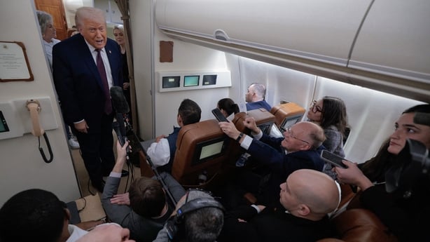 US President Donald Trump speaks to reporters on board Air Force One while flying in between Ireland and Washington
