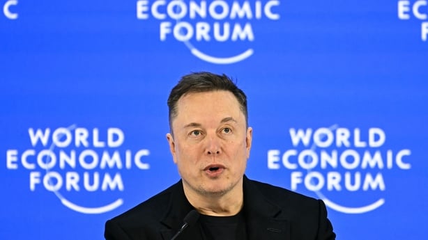 Elon Musk pictured with the World Economic Forum signage behind him