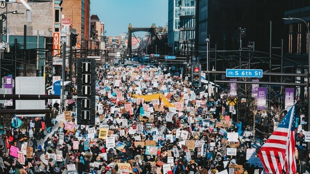 Demonstrators march through downtown Minneapolis holding placards