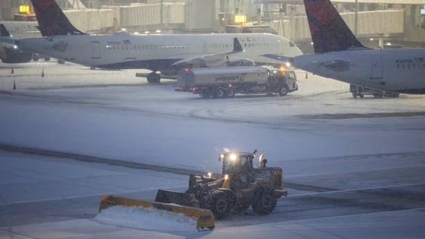 A snow removal machine is seen working on the tarmac of LaGuardia airport