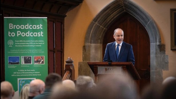 Micheál Martin speaking in UCC in Cork from a podium as audience watches