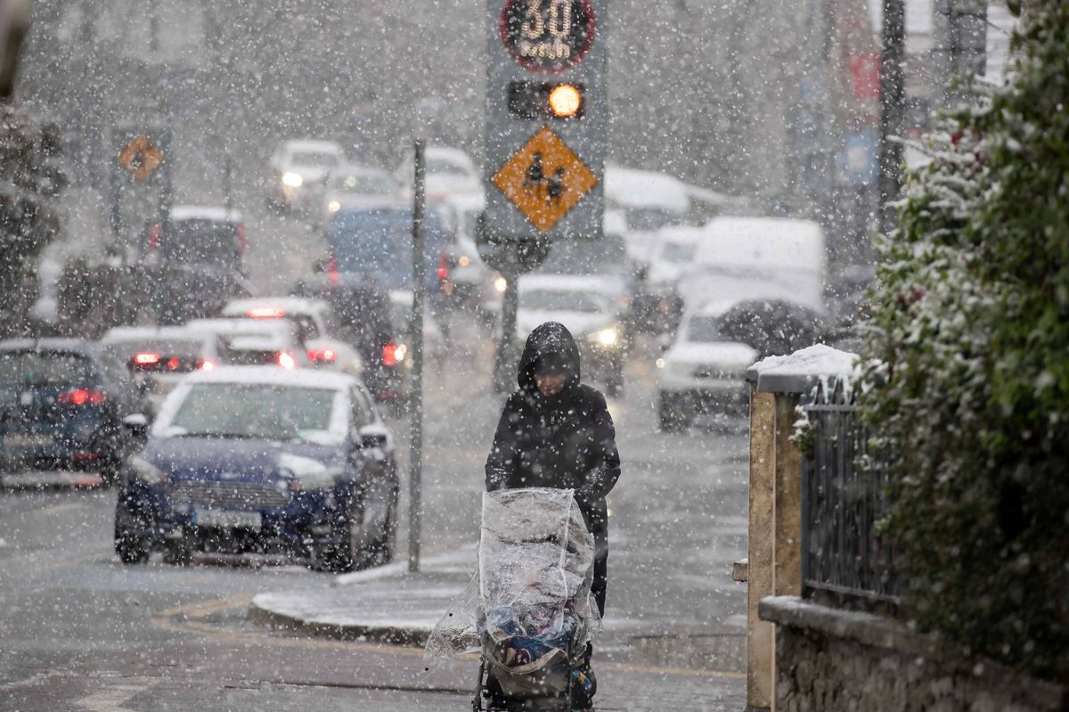 A woman pushing a buggy in the snow
