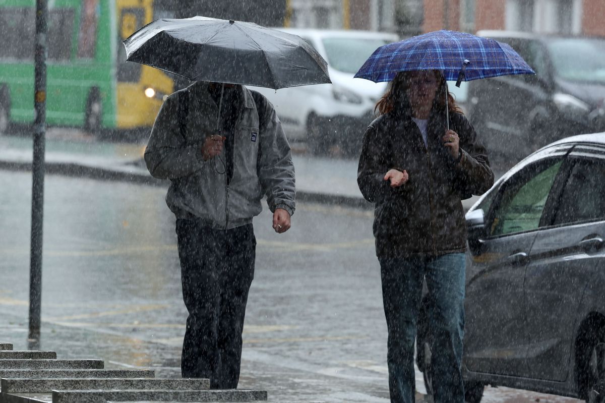 Two people holding umbrellas in the rain