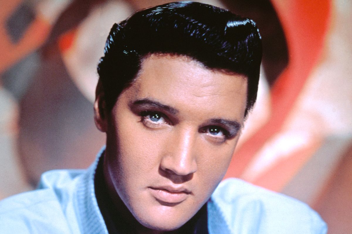 Elvis Presley publicity, head shot, undated photograph. He's wearing a light blue jacket and black shirt.