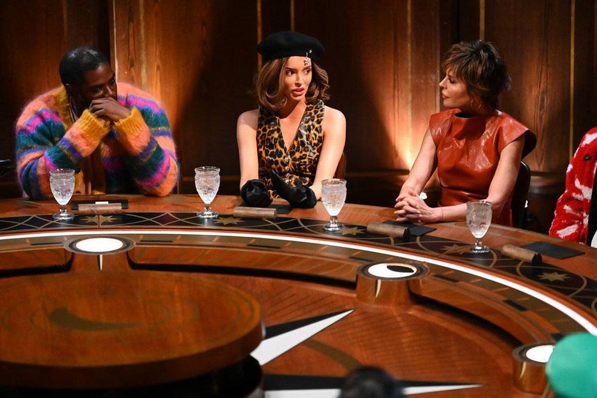 An adult female, wearing a leopard print sleeveless top and a black beret, stands against a warm-toned background, maintaining a composed and serious expression.