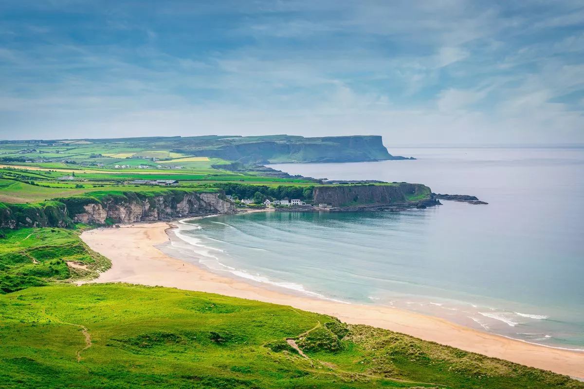 Beautiful view to the green natural White Park Bay Beach in Summer.