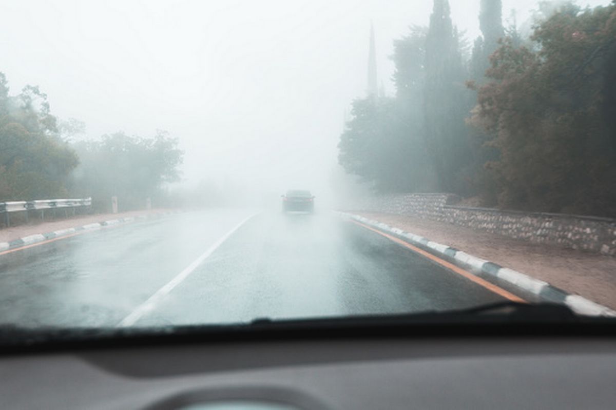 Heavy fog on a suburban highway. Driving in low visibility, risk of a car accident