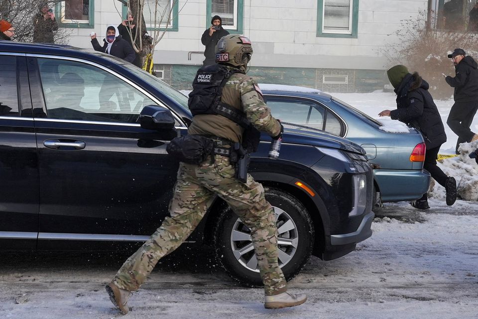 A federal agent runs towards protesters after a driver of a vehicle was shot in Minneapolis, US. REUTERS/Tim Evans.