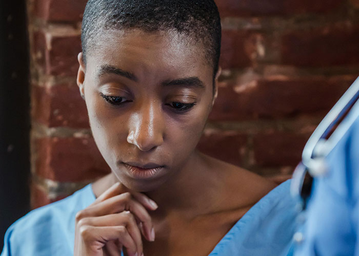 A concerned patient listening intently during a medical consultation with healthcare professionals.