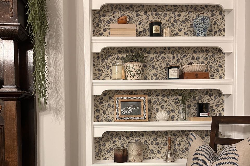 Patterned wallpaper adds depth to shelving units