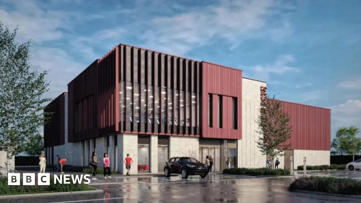 A drawing of a large building with a pale lower level and a brick-red upper level and tall, vertical windows, with a car park in front