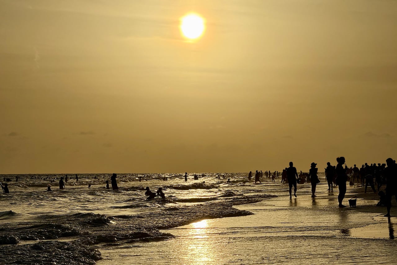 People walk on the beach at sunset at Siesta Beach in Sarasota, Fla., on June 6, 2025.
