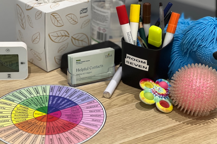A cardboard emotions wheel is on an office desk.