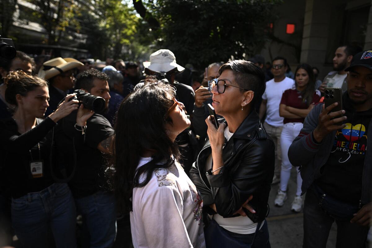 Two women standing outside argue. 