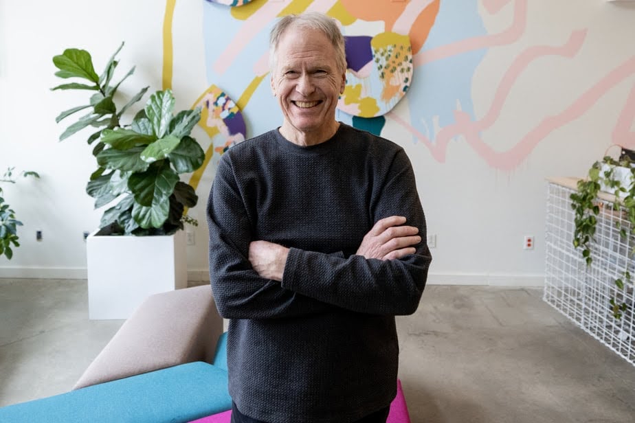 A man smiling and crossing his arms. 