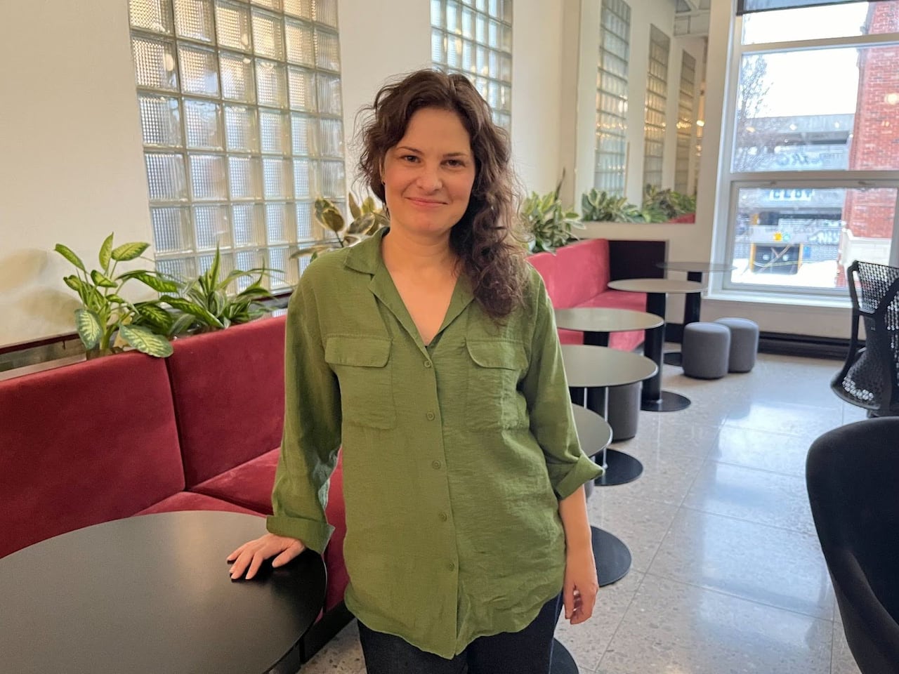 A woman in a green shirt smiling. 
