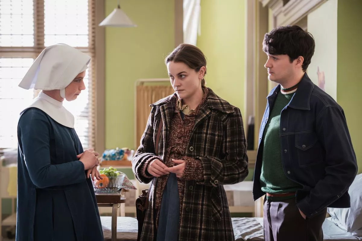 Call the Midwife's Sister Catherine looking concerned while talking to a worried Thelma and Kevin