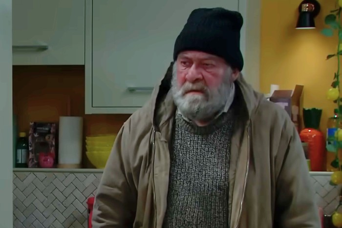 Bear Wolf wears a black hat and large coat, with an overgrown beard, in a scene from Emmerdale