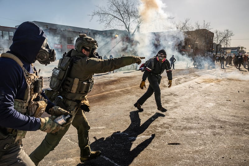 Federal agents use tear gas as they confront protesters in Minneapolis. Photograph: New York Times