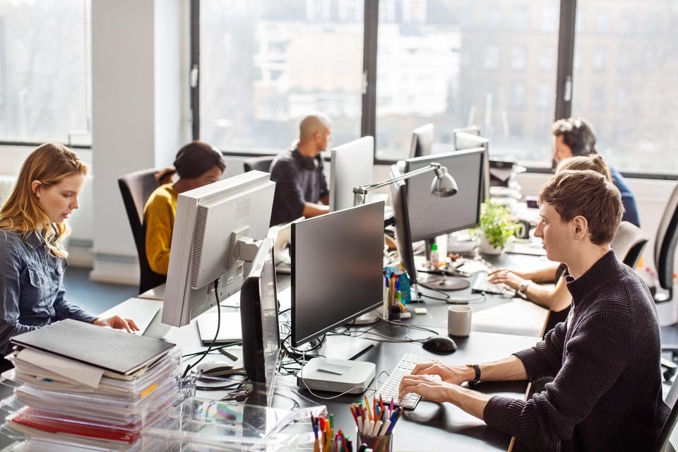 People working at a coworking desk in new office